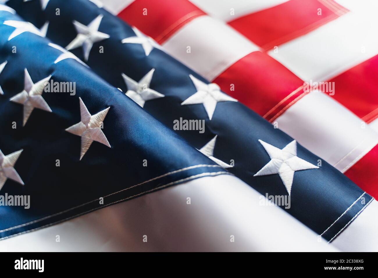 Bandiera USA con strisce rosse e stelle blu, primo piano con messa a fuoco selettiva. Foto Stock
