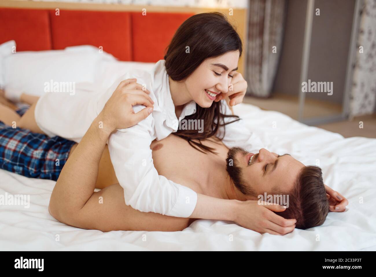 Coppia d'amore romantica in pigiama abbracci a letto a casa, Buongiorno.  Rapporto armonioso nella famiglia giovane. Uomo e donna che riposano insieme  nel loro ho Foto stock - Alamy