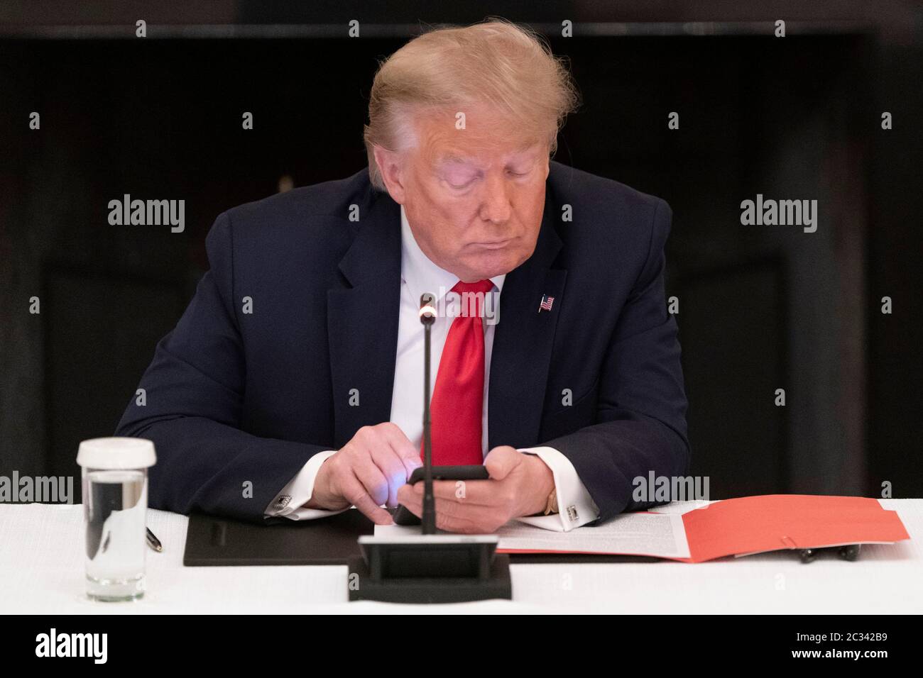 Il presidente degli Stati Uniti Donald J. Trump utilizza un telefono cellulare durante una tavola rotonda con i governatori sulla riapertura delle piccole imprese americane alla Casa Bianca credito: Chris Kleponis/Pool via CNP /MediaPunch Foto Stock