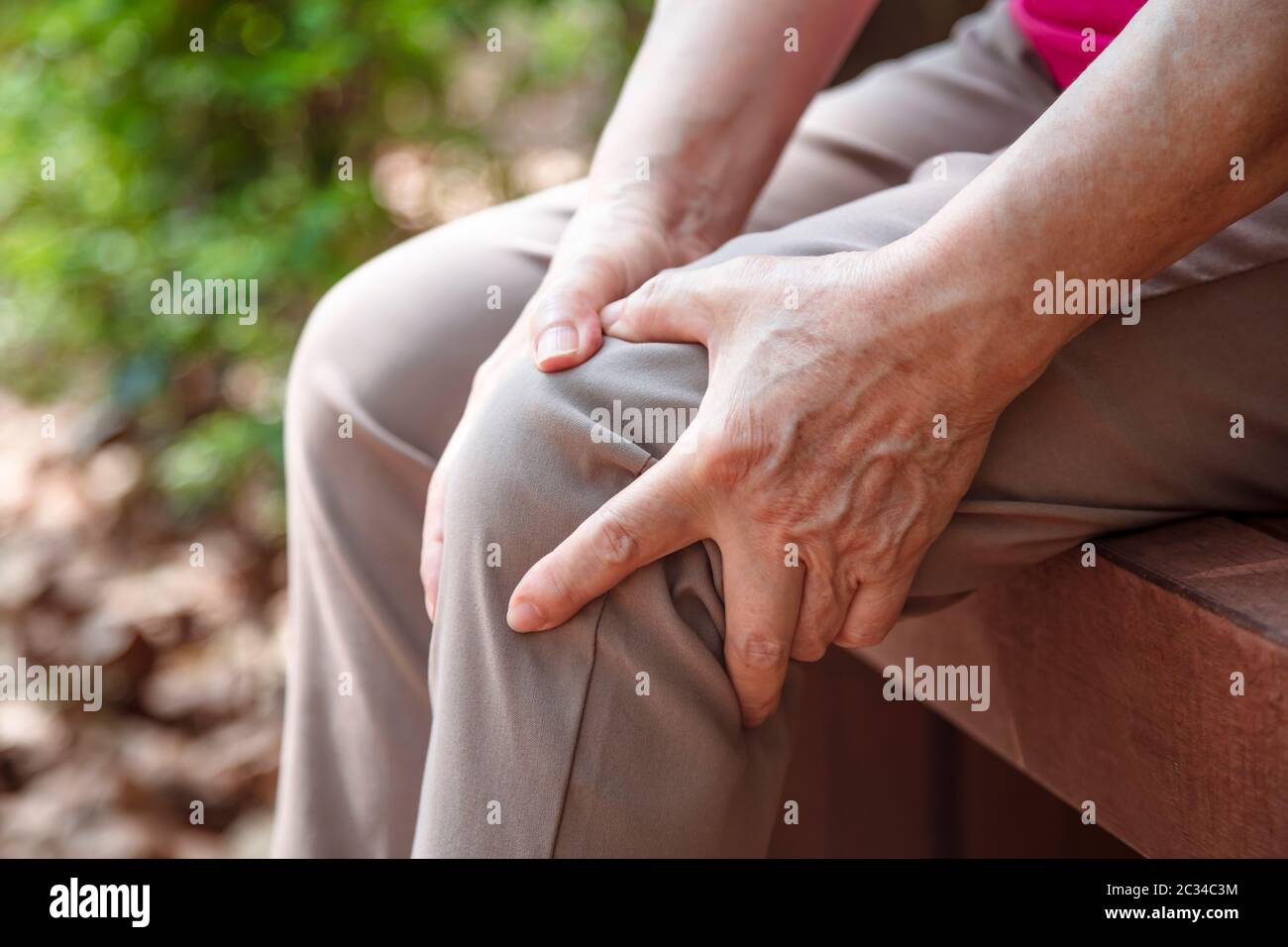 donna anziana che soffre di dolore alle gambe e al ginocchio Foto Stock