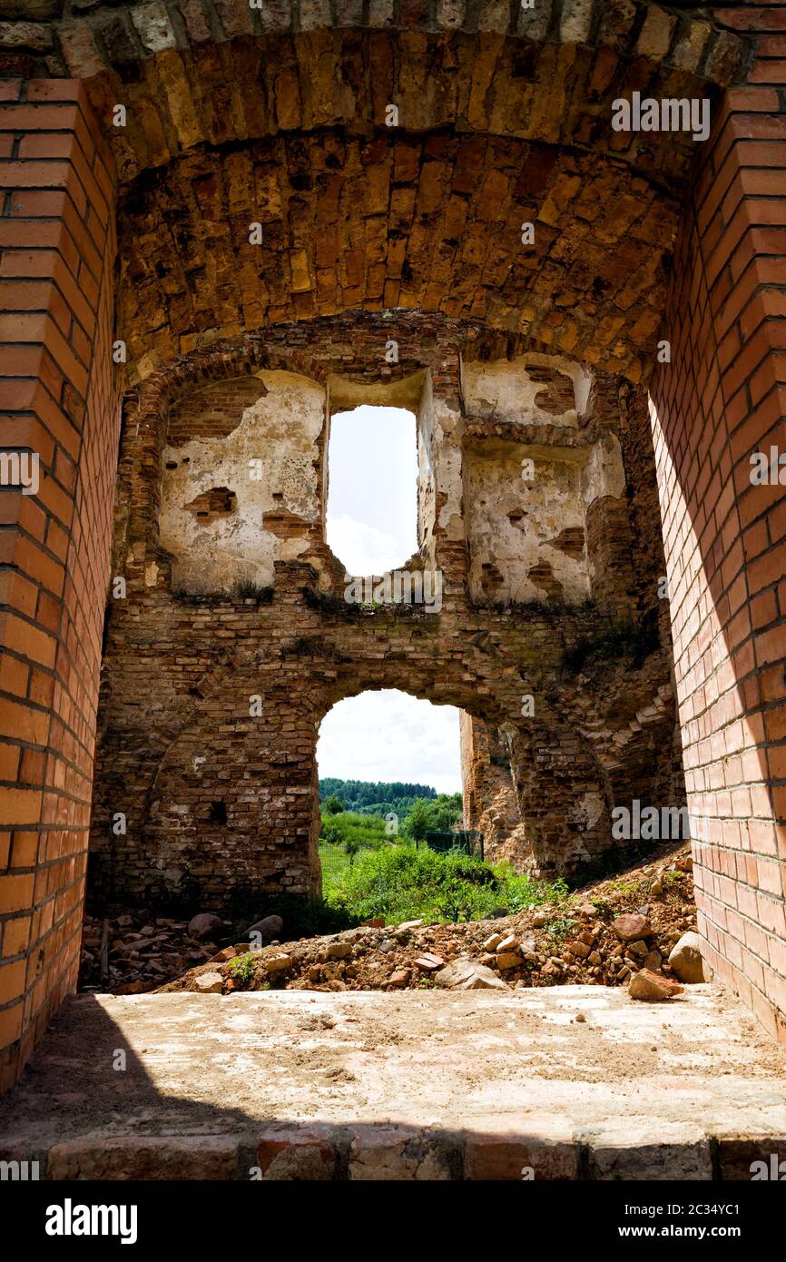 Finestre vuote in un abbandonato rovinato edificio in mattoni rossi, le rovine di una fortezza in Europa Foto Stock