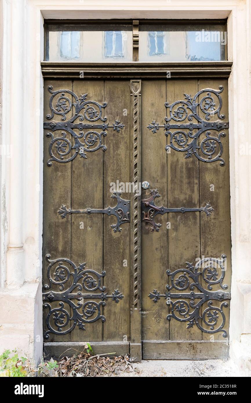 Portale d'ingresso storico con finiture riccamente decorate sulla porta in legno color oliva. Foto Stock