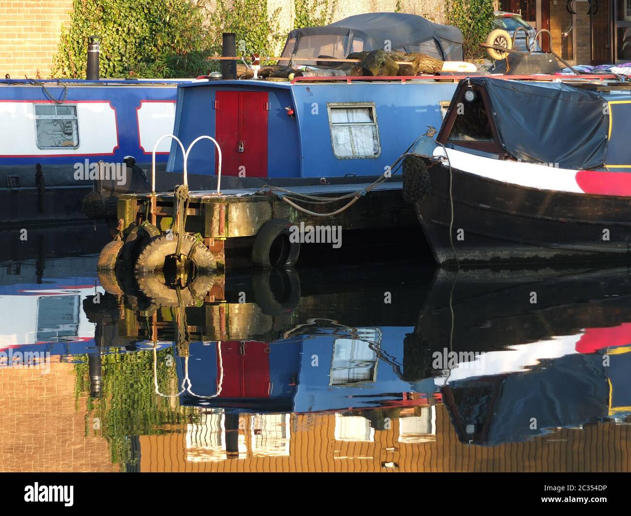 vecchie barche strette e chiatte convertite in case galleggianti ormeggiate nel porto turistico di brighouse bacino nel west yorkshire Foto Stock