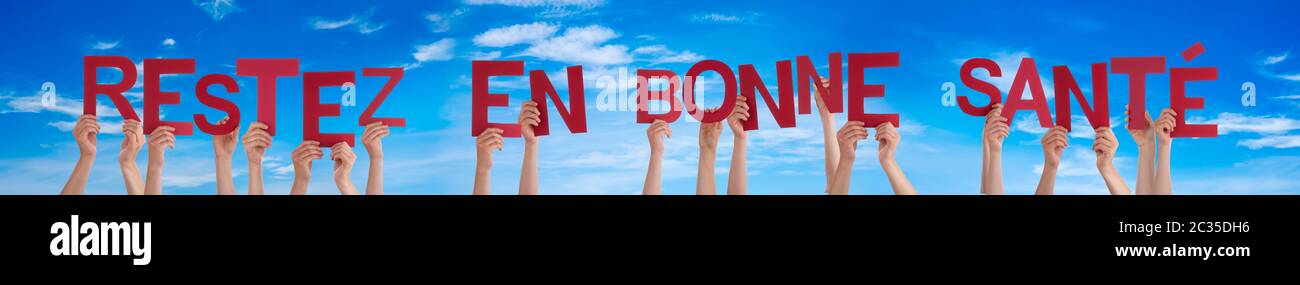 People Hands Holding Colorato Francese Word Restez En Bonne Sante Significa Rimanere Sani Cielo Blu Come Sfondo Foto Stock Alamy