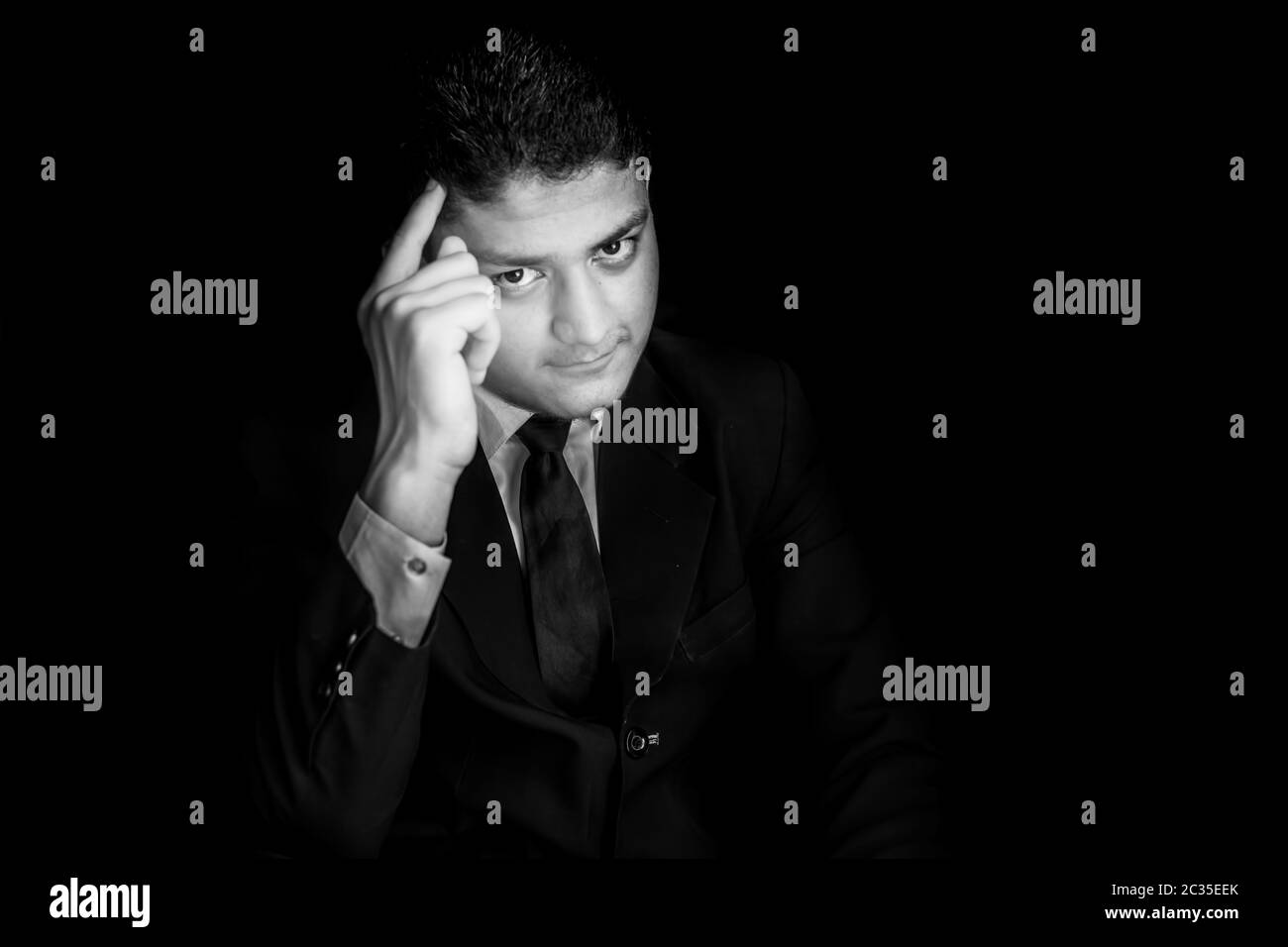 Ritratto di pensiero di uomo d'affari, che si pone come un amministratore delegato intelligente isolato su sfondo nero. Foto Stock