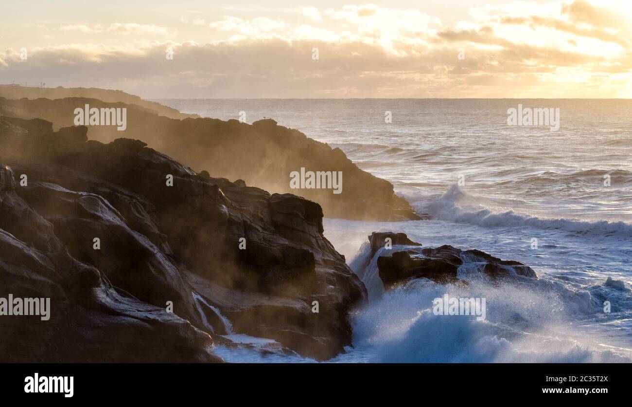Infrangere le onde sulla costa della California al tramonto Foto Stock