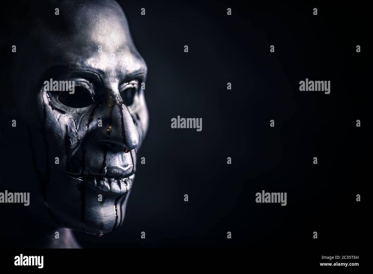 Scary figura con creepy sanguinosa maschera nel buio Foto Stock