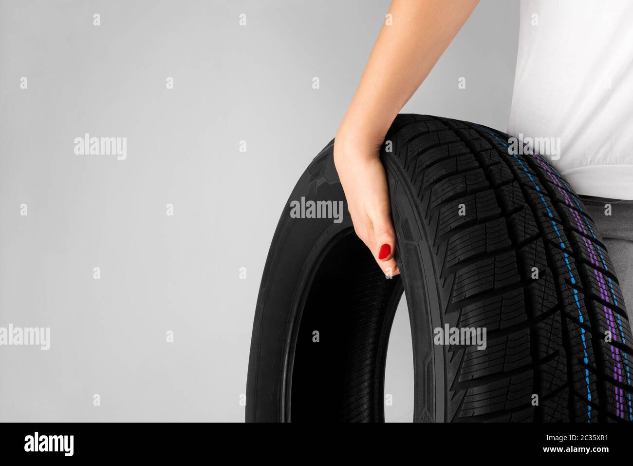 Concetto creativo ragazza che indossa la gomma dell'automobile. Simbolo di duro lavoro, femminismo. Uguaglianza di genere, diversità. Foto Stock
