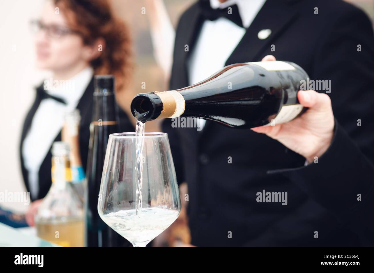 Esperienza di degustazione con un sommelier che serve un bicchiere di Moscato d'Asti (Moscato) spumante ad Alba (Piemonte, Italia) Foto Stock