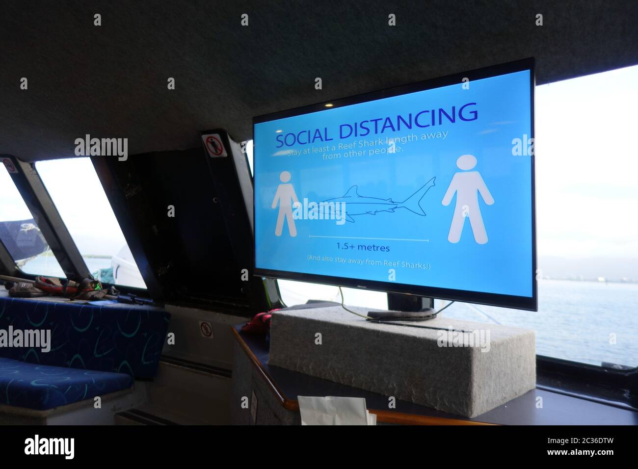 Cartello che avverte circa la distanza sociale sul traghetto turistico che esce alla Grande barriera Corallina da Cairns, Queensland, Australia. No PR Foto Stock