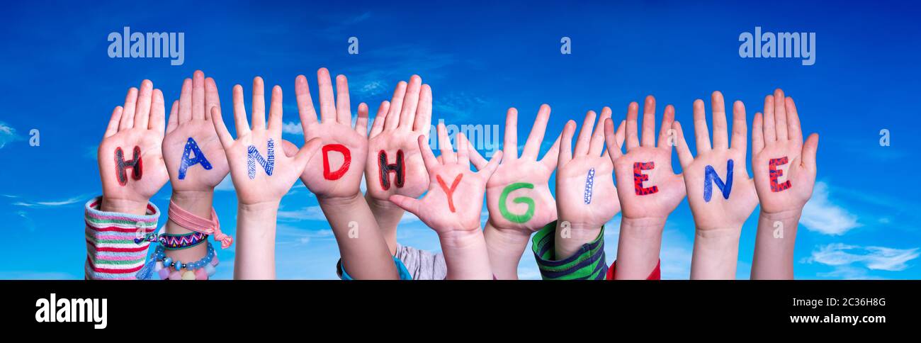 Kids Hands Holding colorful tedesco Word igiene delle mani significa igiene delle mani. Cielo blu come sfondo Foto Stock