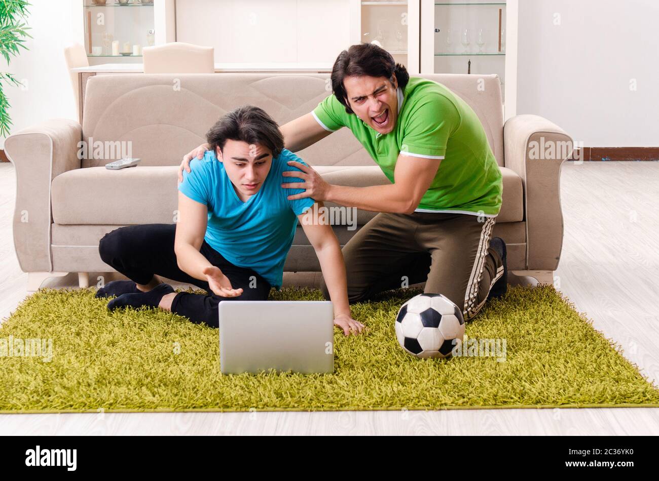 Amici che guardano il calcio a casa Foto Stock