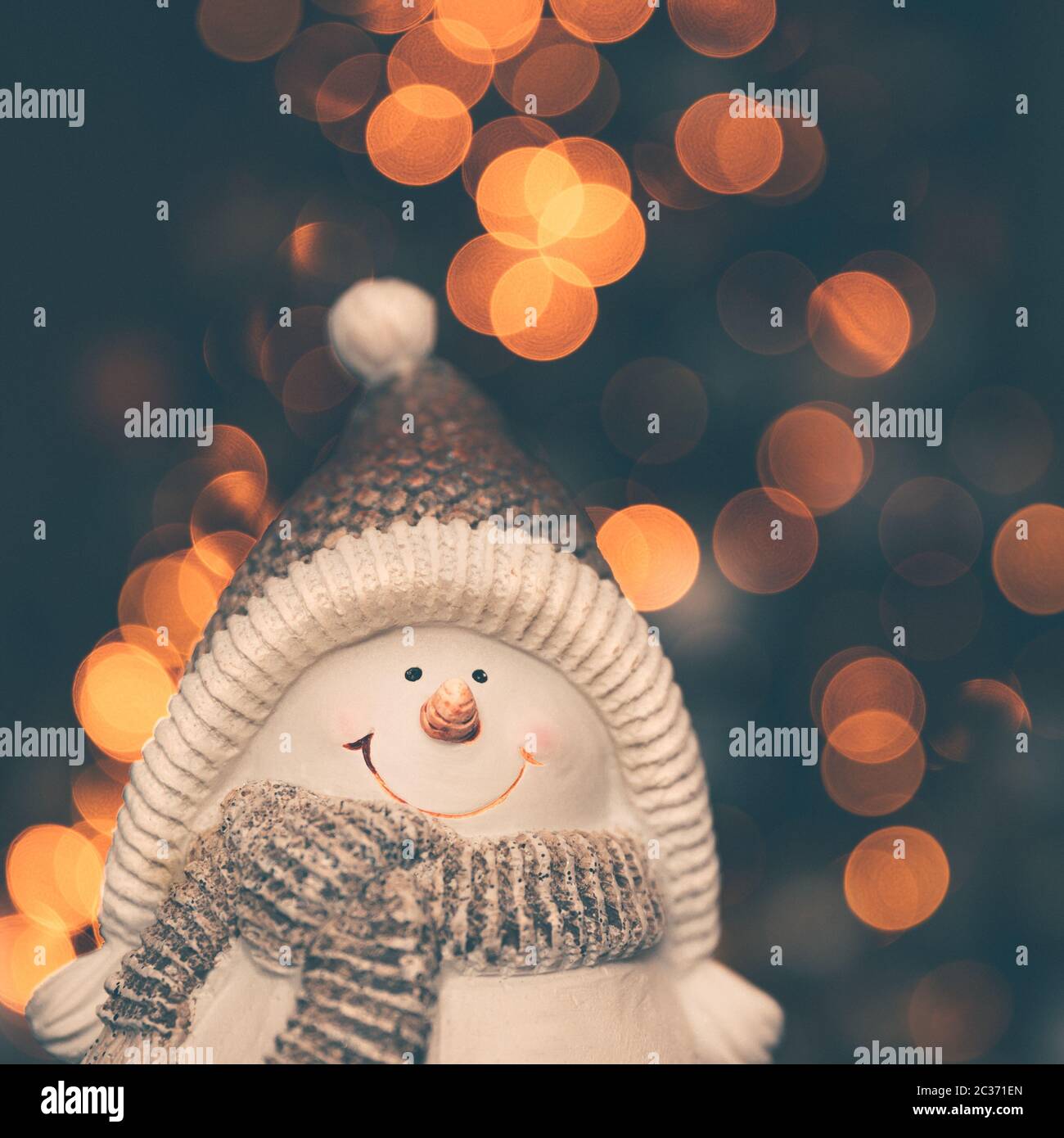 Decorazione di natale, grazioso piccolo giocattolo pupazzo di neve su albero di natale luci, vacanze sfondo bokeh, tradizionale simbolo in inverno, Buon Natale e Happ Foto Stock