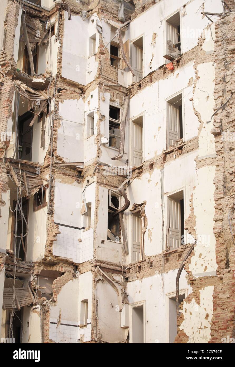 Vecchio edificio demolito a più piani con mattoni e infissi. Demolizione, ristrutturazione, sisma Foto Stock