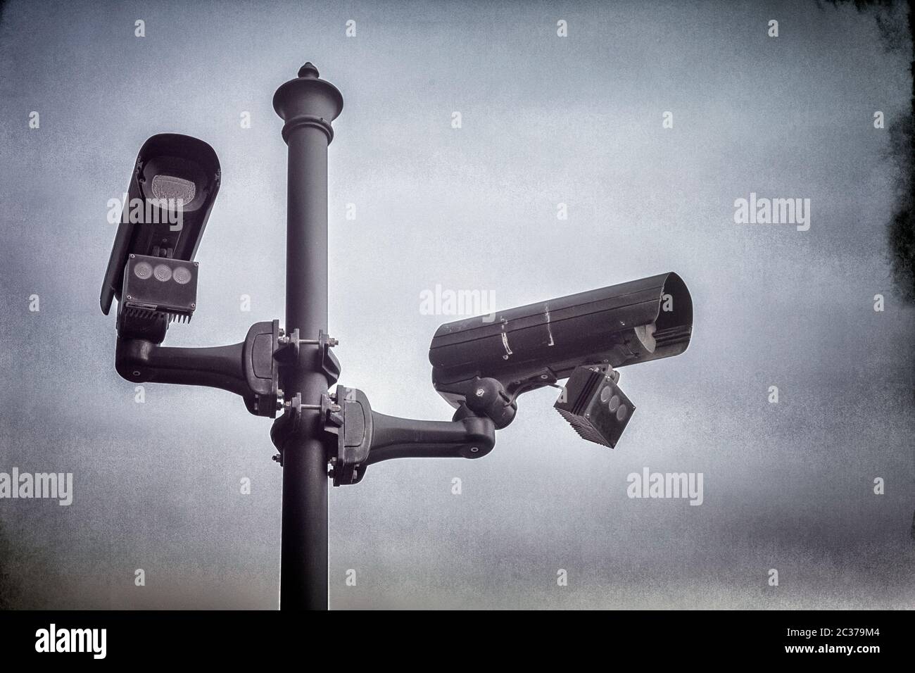 Due telecamere di sicurezza TVCC montate su un palo in strada. Foto Stock