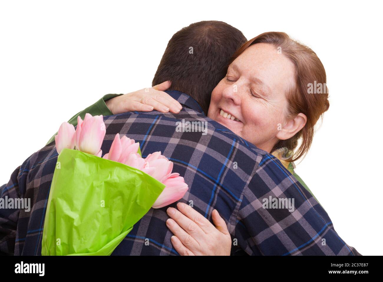 Uomo con bouquet di tulipani rosa nascosto dietro la schiena abbracciando la donna anziana, isolato su sfondo bianco. Giornata delle madri, Valenti Foto Stock