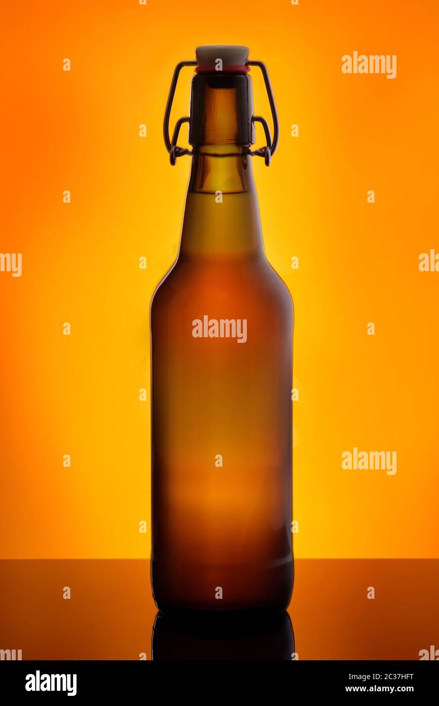 Birra bruna bootle con swing top in arancione back lit Foto Stock