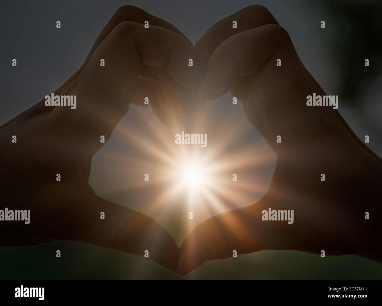 Womans mani cattura la luce solare sunray mentre messa a forma di cuore Foto Stock