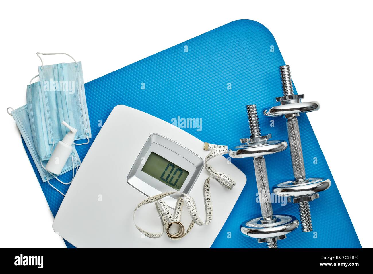 Attrezzature sportive, bilance, maschere mediche e igienizzatore su sfondo bianco. Vista dall'alto, spazio di copia. Fitness. Periodo di isolamento. Peso e controllo della salute Foto Stock