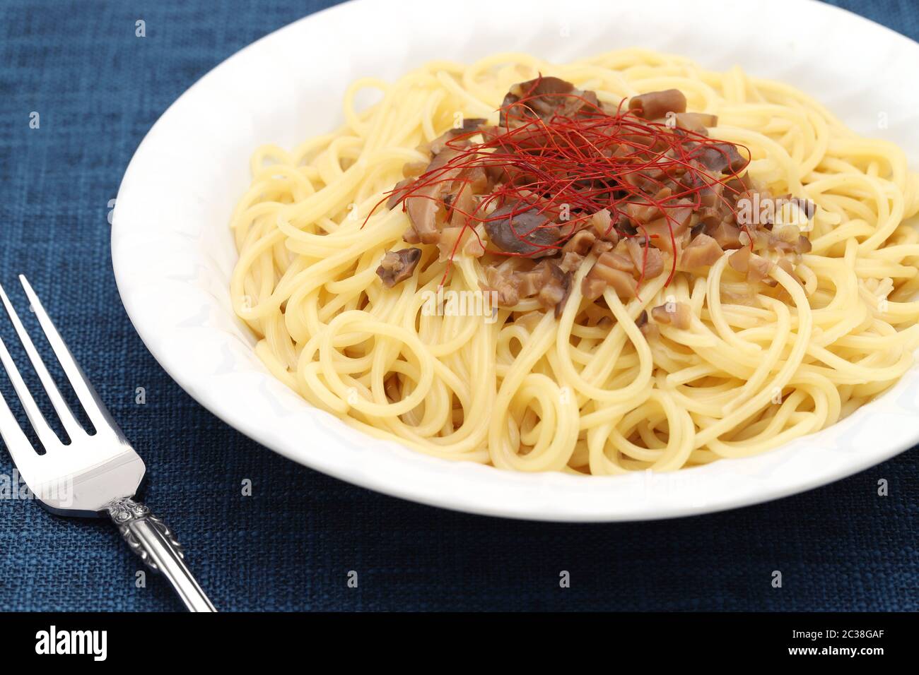 Spaghetti di pasta fresca con funghi shimeji, panna e formaggio sul tavolo Foto Stock