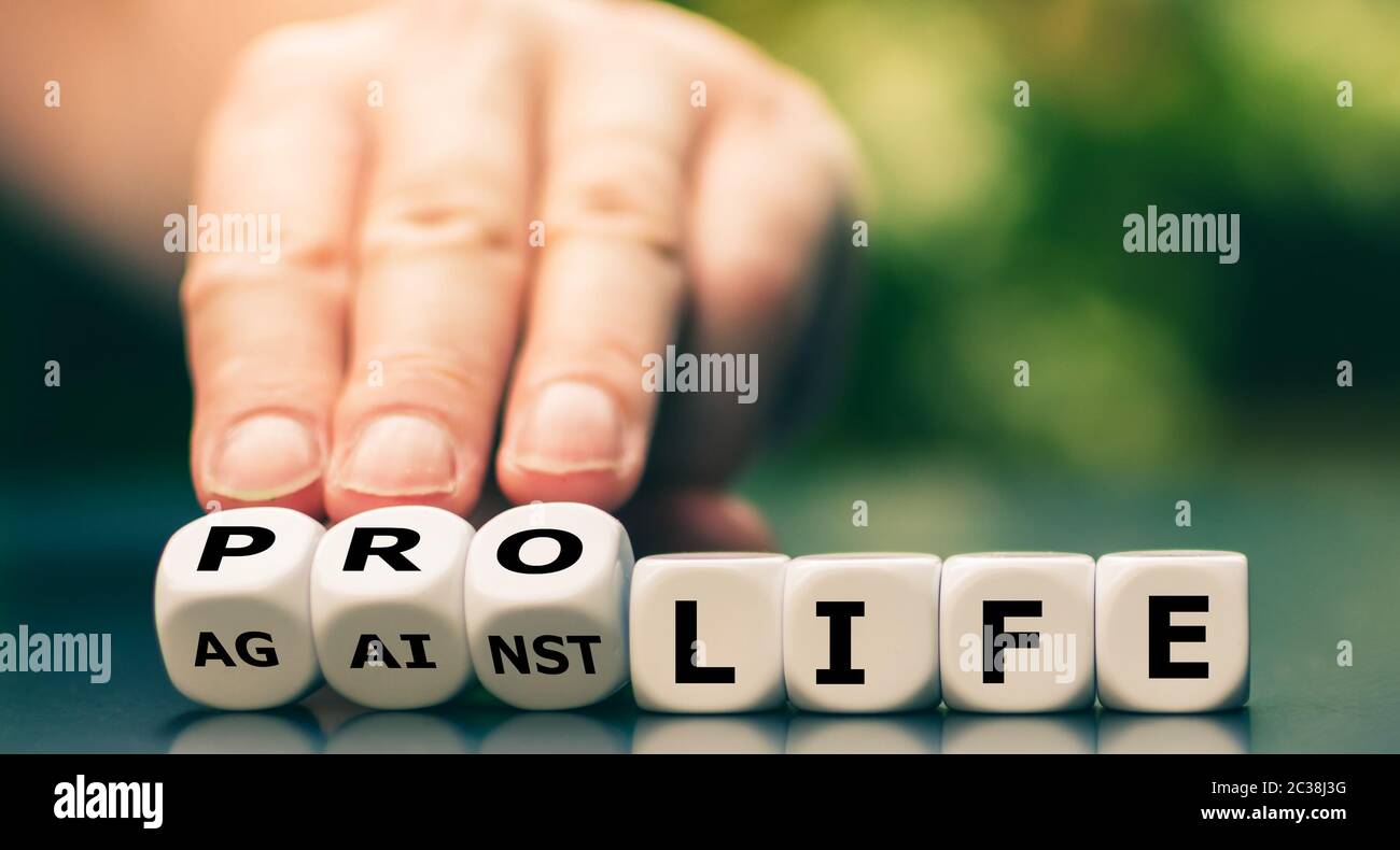 La mano trasforma i dadi e cambia l'espressione 'contro la vita' in 'pro vita'. Foto Stock