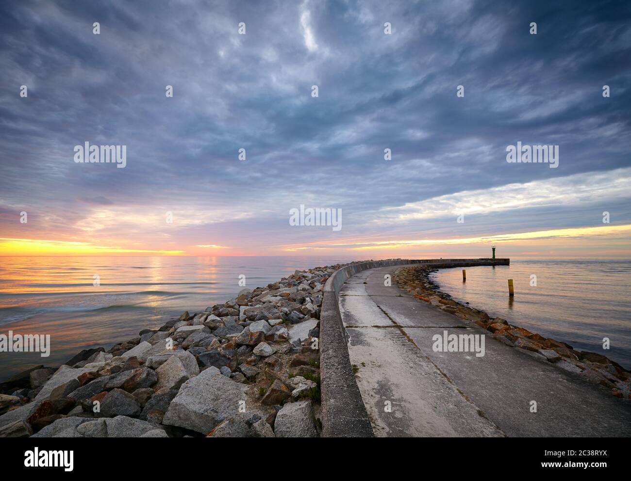 Molo roccioso all'ingresso del porto Mrzezyno al tramonto, Polonia. Foto Stock