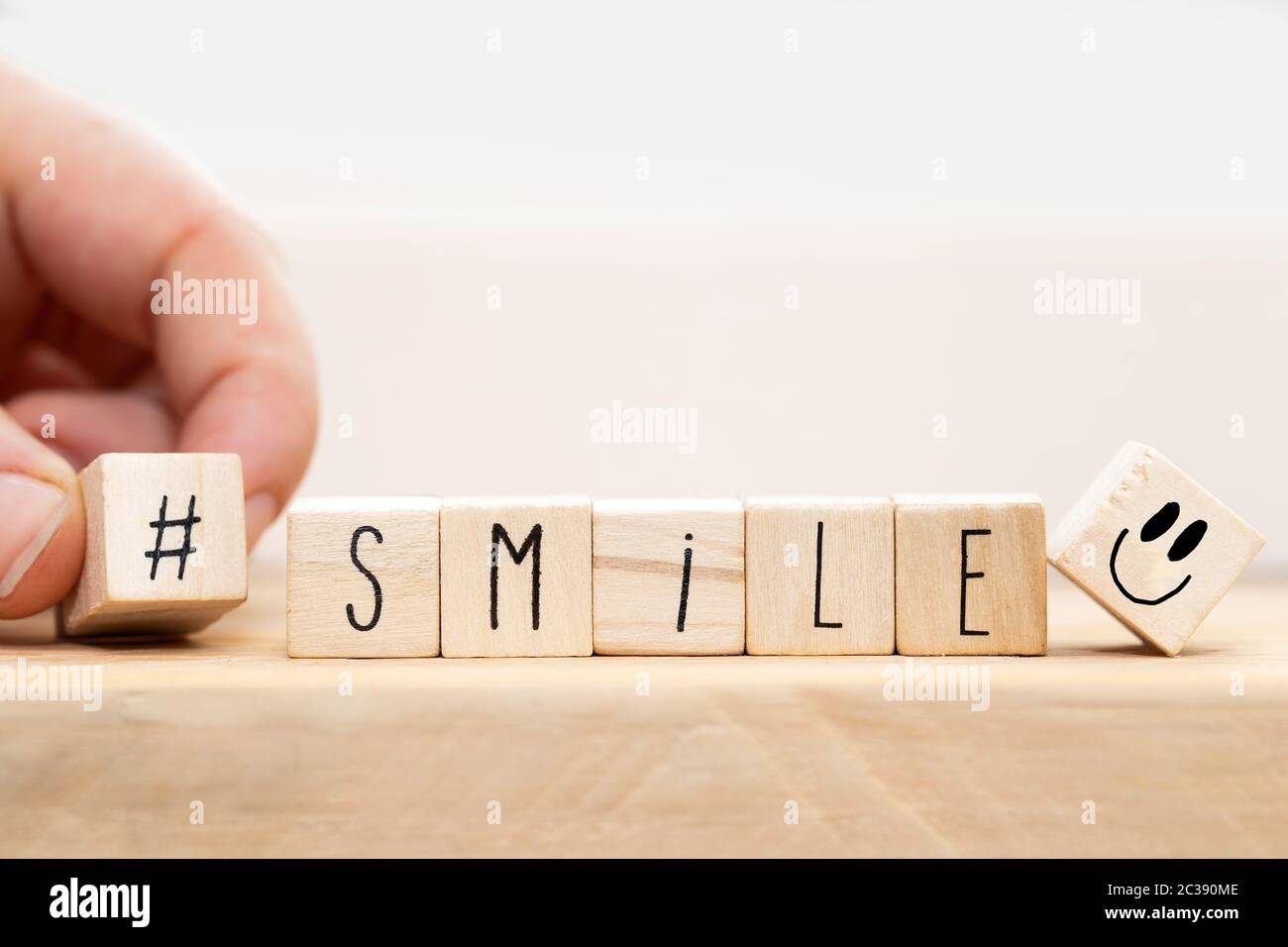 Cubi di legno con un hashtag e la parola sorriso, social media sfondo concetto close-up Foto Stock