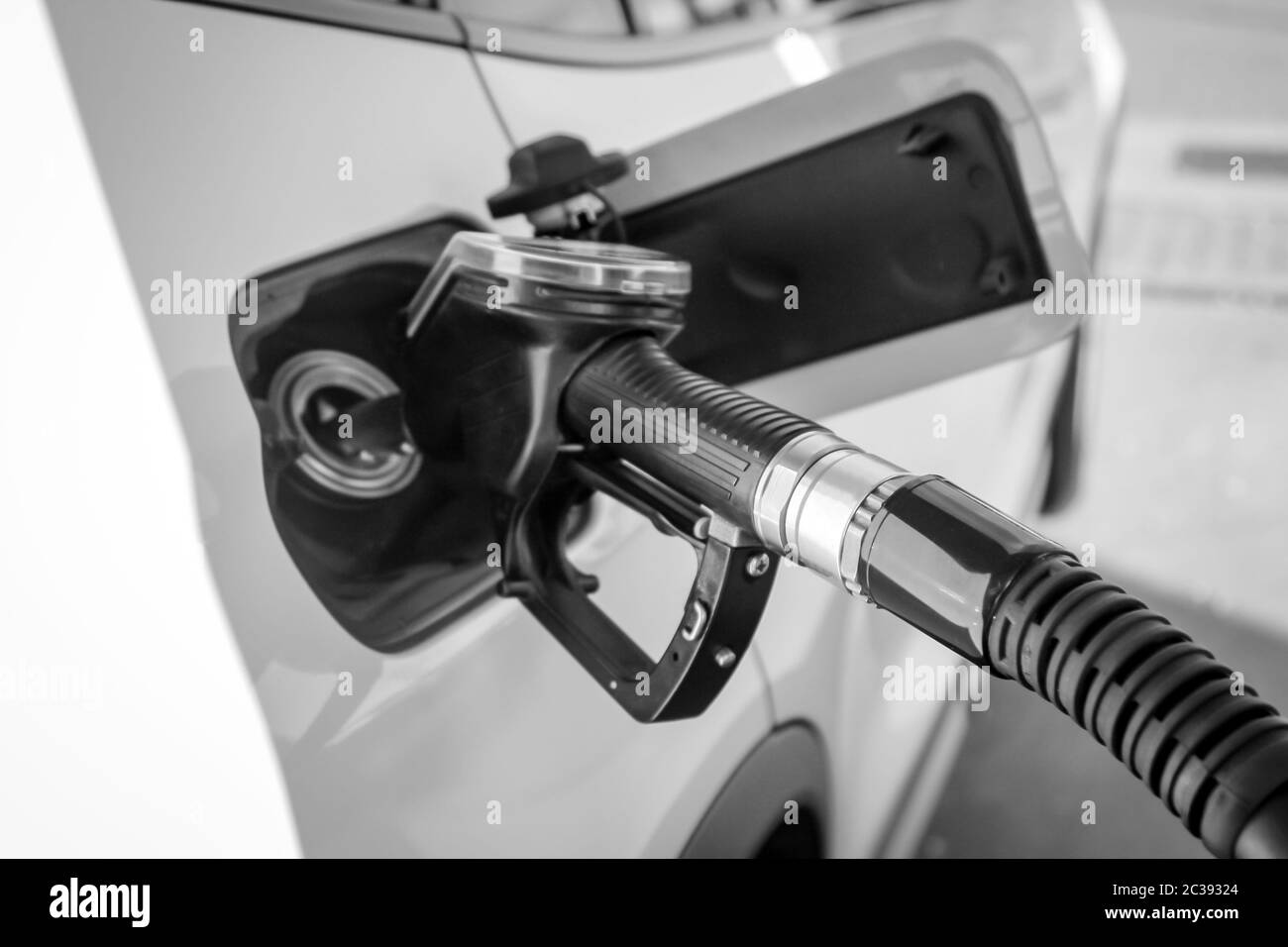 Un bocchettone di rifornimento si trova nell'apertura del serbatoio del carburante di una vettura Foto Stock