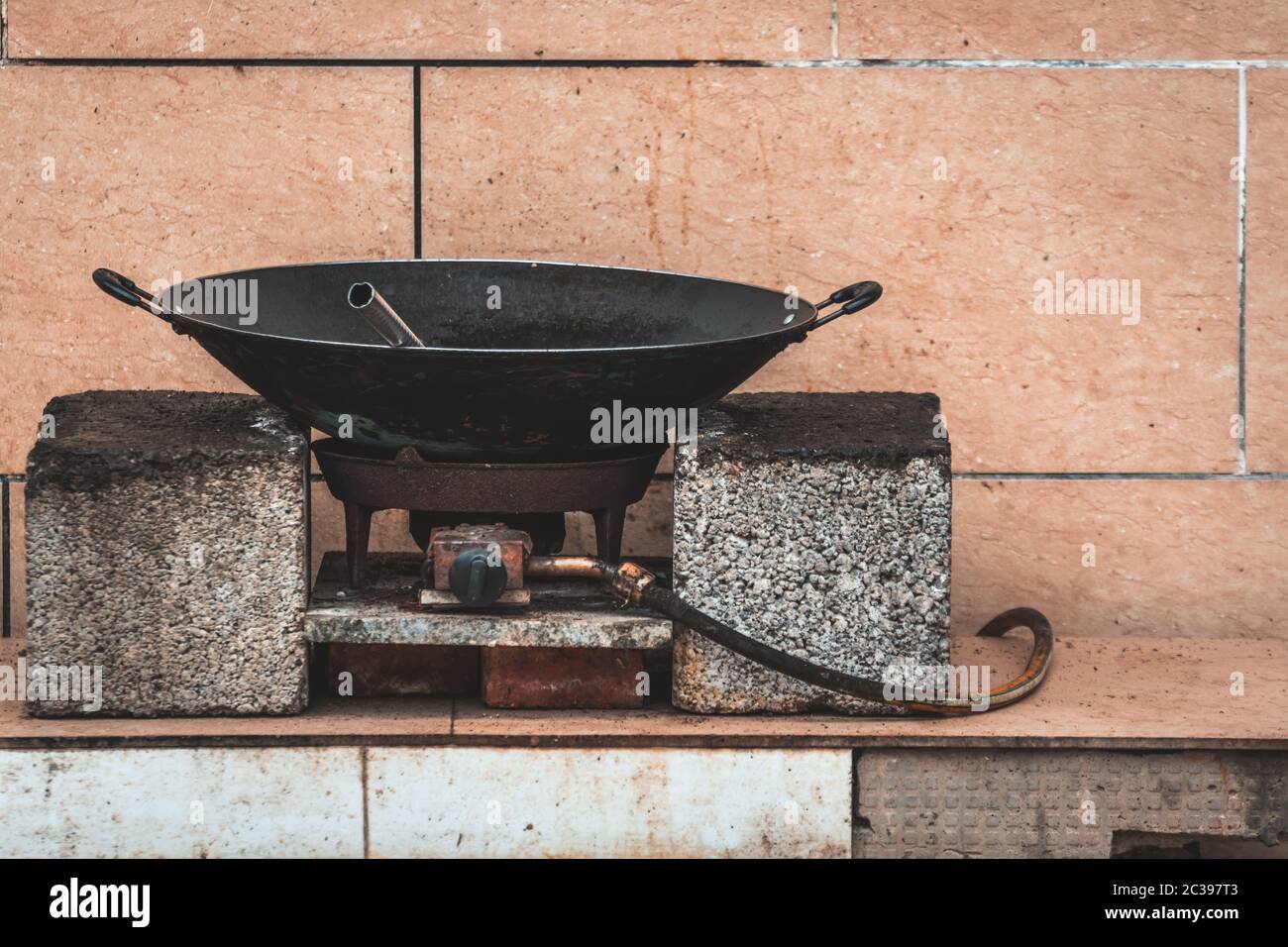 Vecchio wok di metallo nero su un fornello a gas Foto Stock