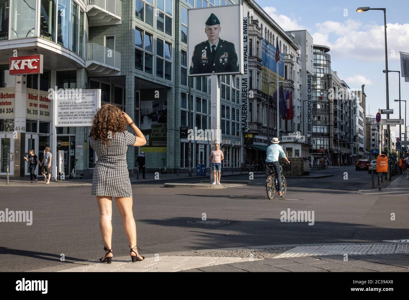 Una donna scatta una foto al Checkpoint Charlie sulla Friedrichstrasse, il muro di Berlino che attraversa Berlino Est e Berlino Ovest durante la Guerra fredda. Foto Stock