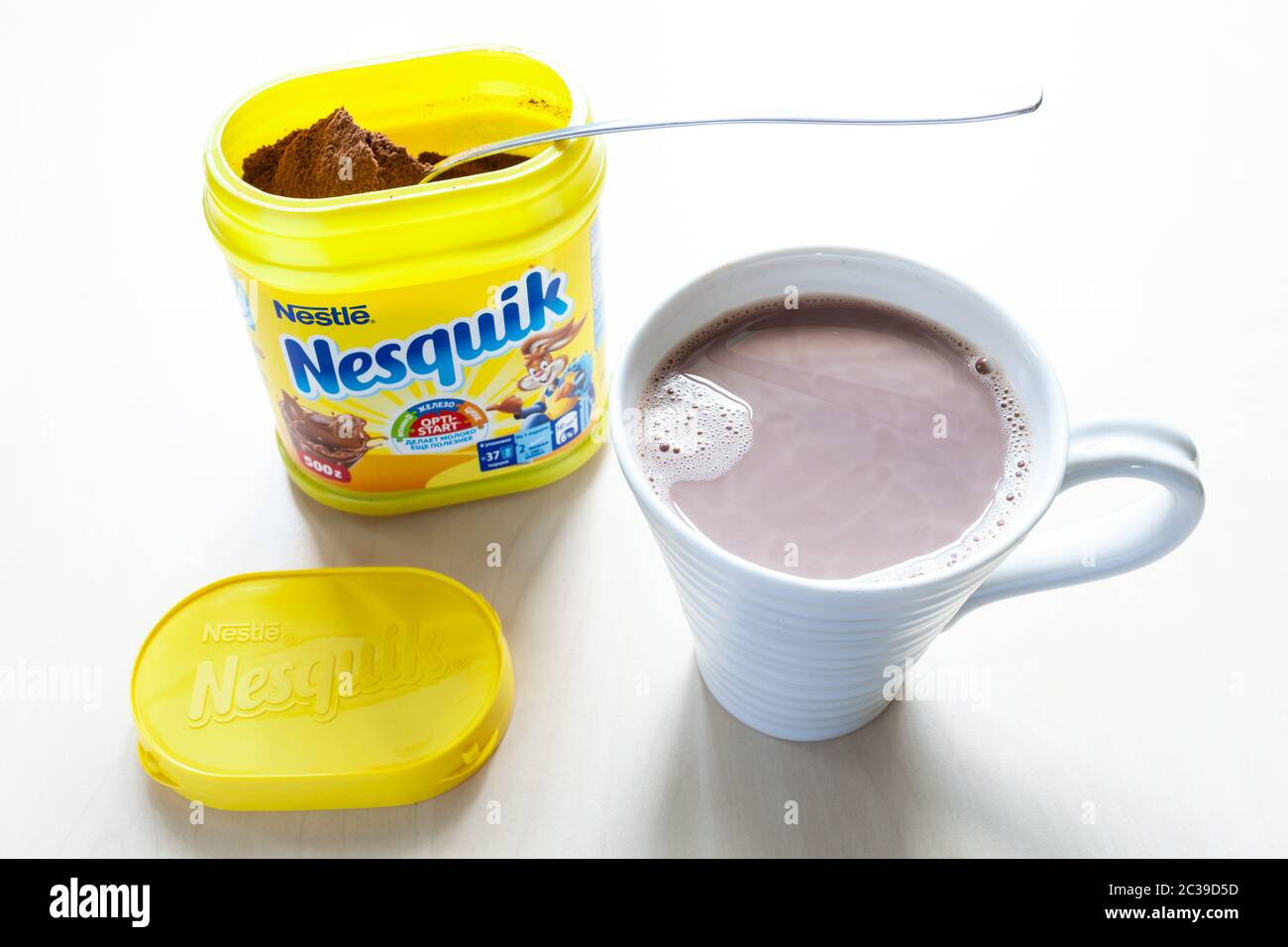 MOSCA, RUSSIA - 16 GIUGNO 2020: Vista dall'alto del vaso aperto di Nesquik con cucchiaio e mup con cacao sul tavolo. La polvere di cioccolato Nesquik è stata introdotta in 1,2 g di polvere di cioccolato Foto Stock