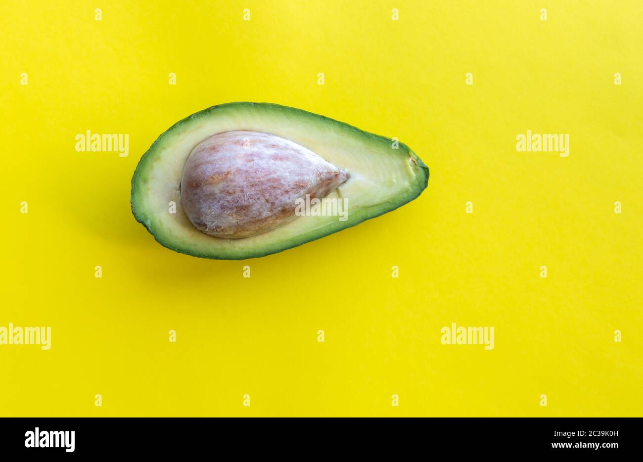 Metà dell'avocado su sfondo giallo Foto Stock