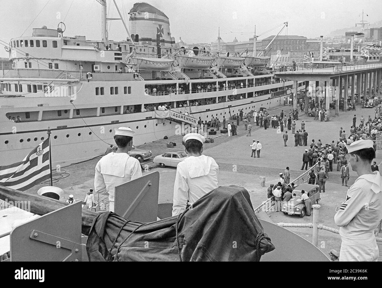 I passeggeri salono a bordo della nave 'Agamemnon' nel porto del comune di Pireo ad Atene. Gli spettatori si trovano dietro una barriera. Foto Stock