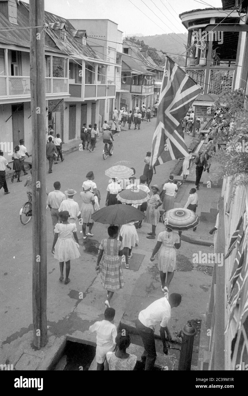 Vivace strada su Antigua. Il British Union Jack è appeso a un muro di casa, Antigua ha ottenuto la sua indipendenza solo nel 1981. Foto Stock