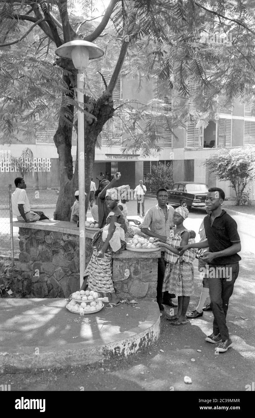 La frutta viene venduta all'ombra di un albero, sul lato della strada di fronte a un hotel in Sierra Leone. Foto Stock