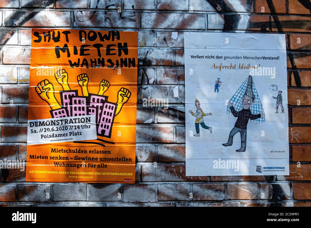 Due poster su parete in mattoni, alloggiamento per tutte le dimostrazioni e tenere un poster a distanza sociale - Mitte, Berlino Foto Stock