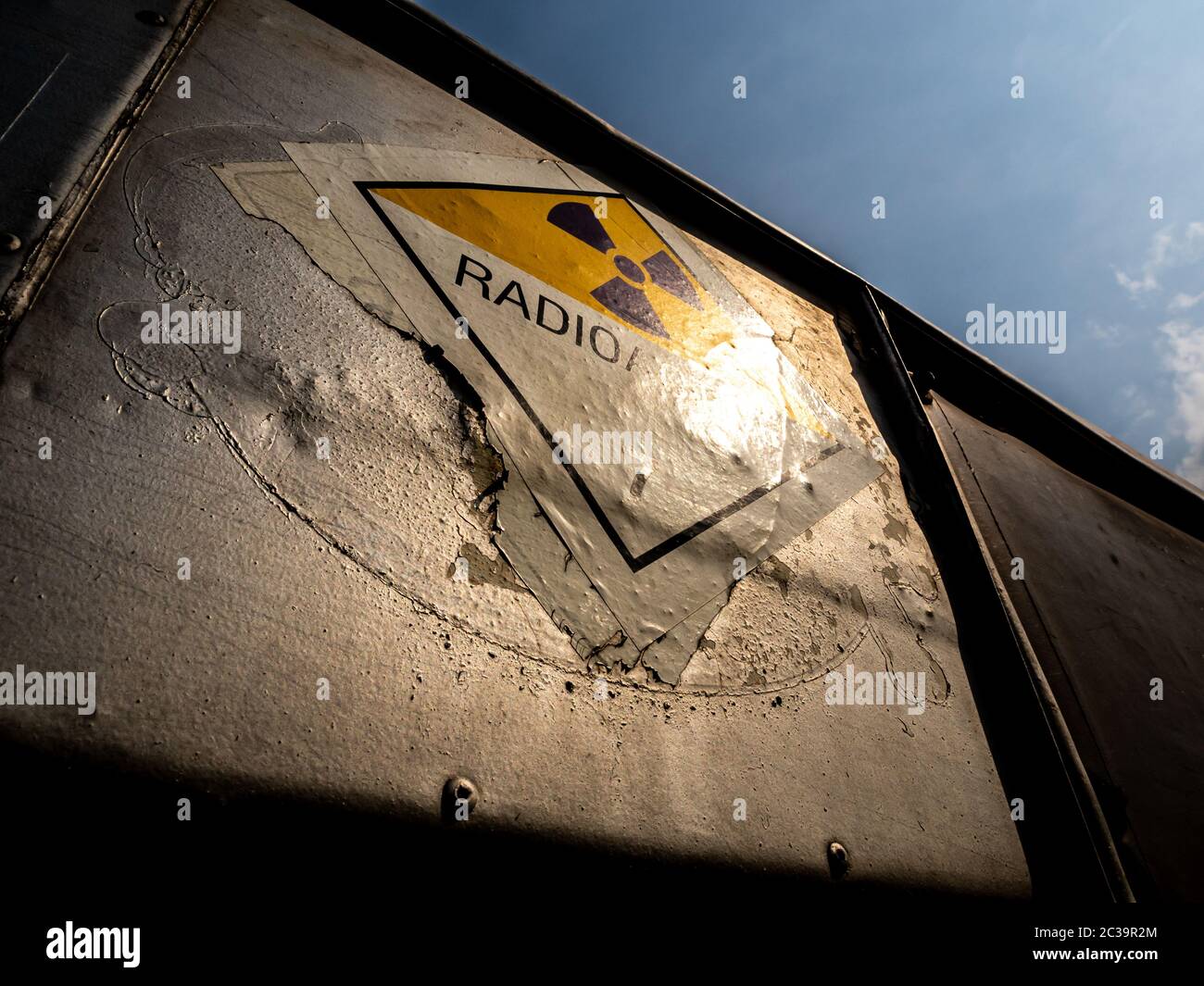 Etichetta di trasporto delle radiazioni adesivo di classe 7 applicato sul vecchio adesivo sul contenitore in alluminio del carrello di trasporto Foto Stock