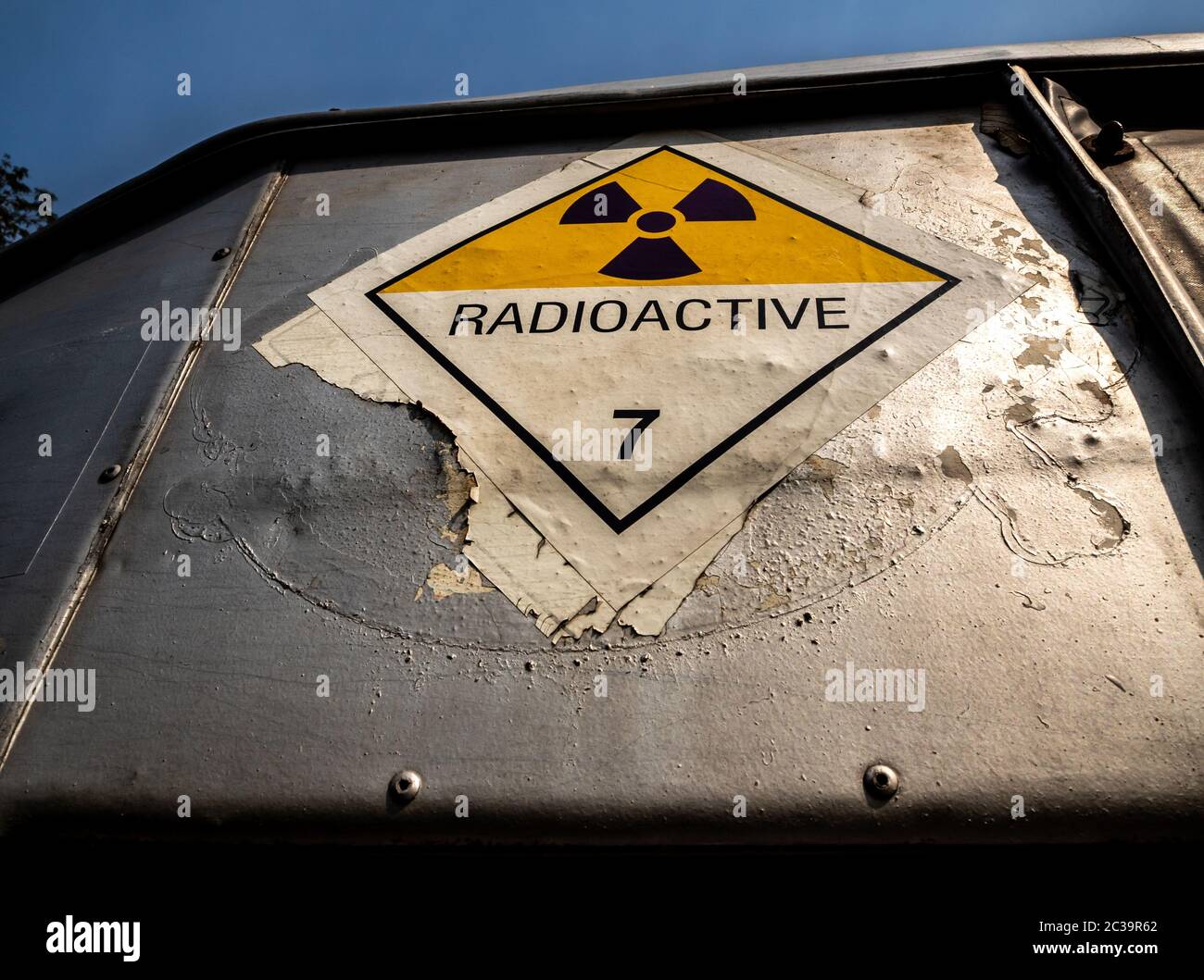 Etichetta di trasporto delle radiazioni adesivo di classe 7 applicato sul vecchio adesivo sul contenitore in alluminio del carrello di trasporto Foto Stock