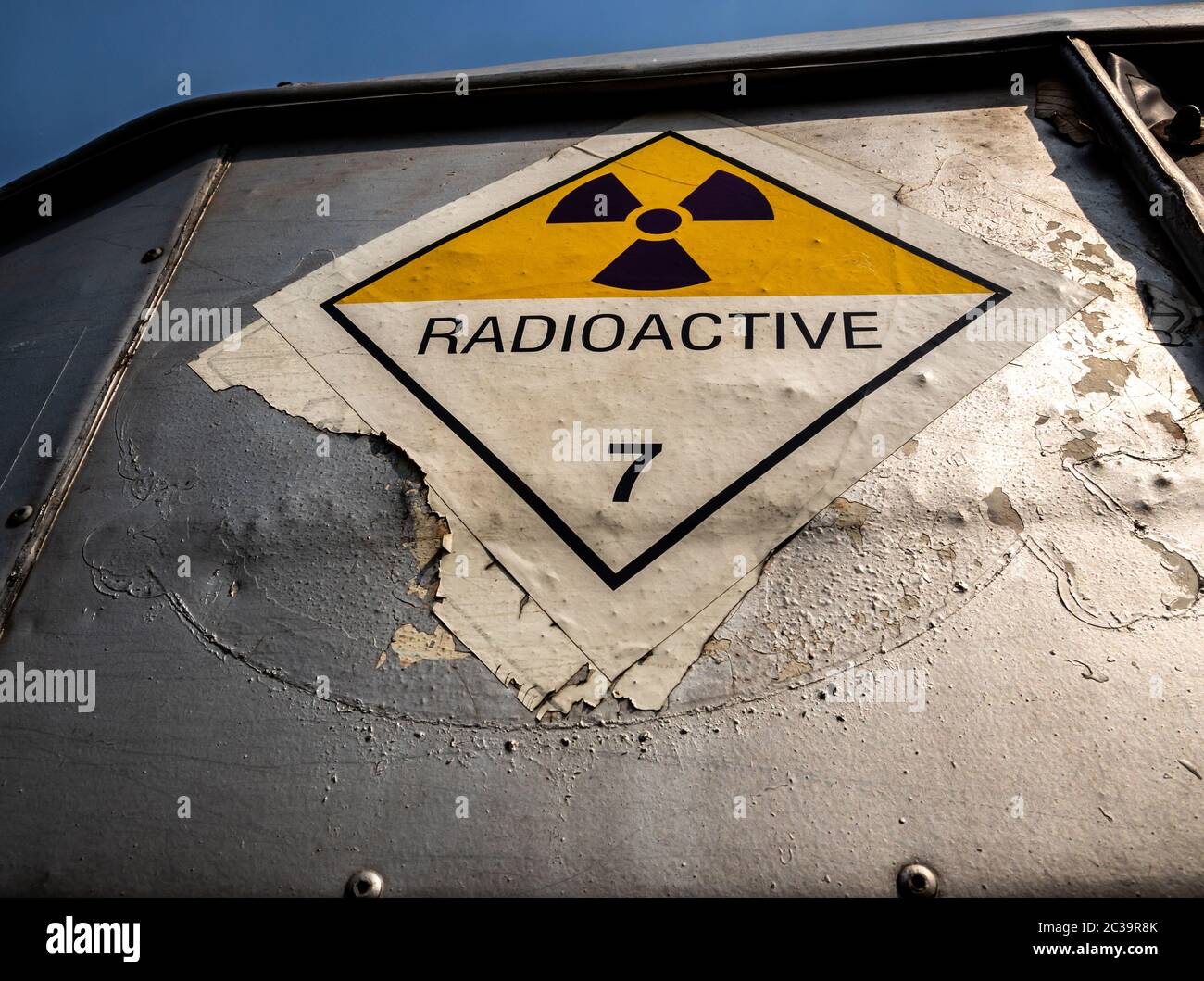 Etichetta di trasporto delle radiazioni adesivo di classe 7 applicato sul vecchio adesivo sul contenitore in alluminio del carrello di trasporto Foto Stock