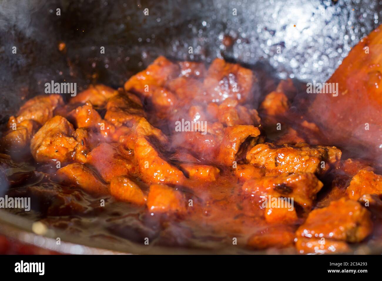 Frittura di pezzi di carne in una padella. La cottura della carne con sugo di carne. Arrosto di carne. Cottura a casa. Foto Stock