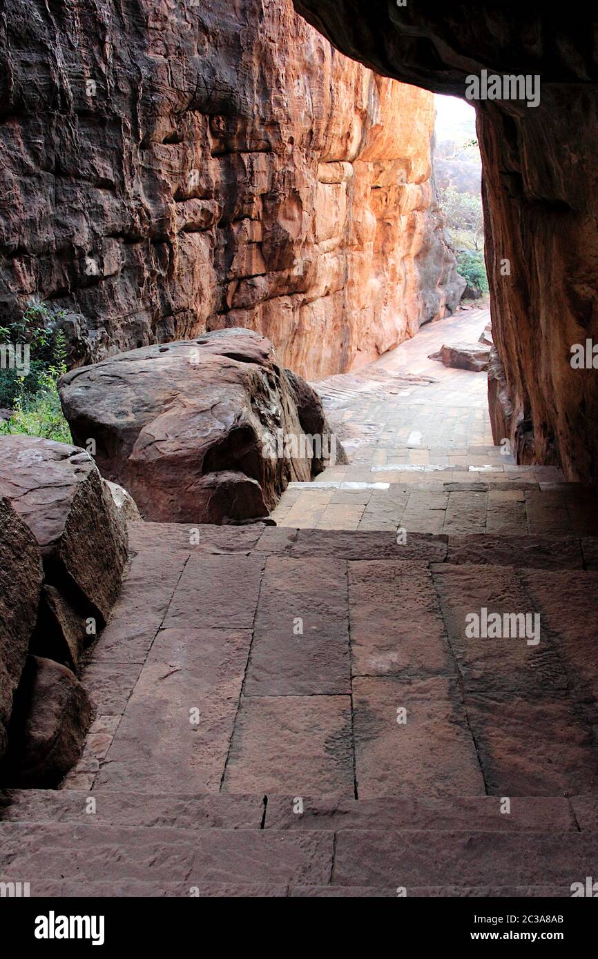 Vestito pavimentazione di pietra tra alte rocce che conduce a nord della collina a Badami, Karnataka, India, Asia Foto Stock