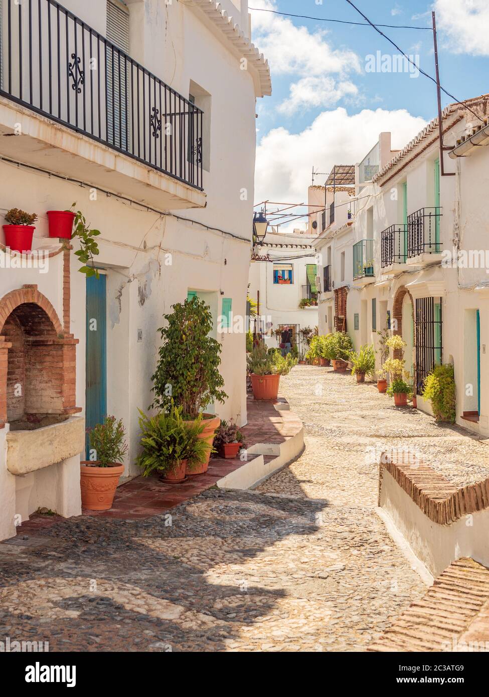Frigliana costa del Sol Spagna Aprile 18 2019 stradine strette che si snodano tra case con colorate piante in vaso e strada acciottolata Foto Stock