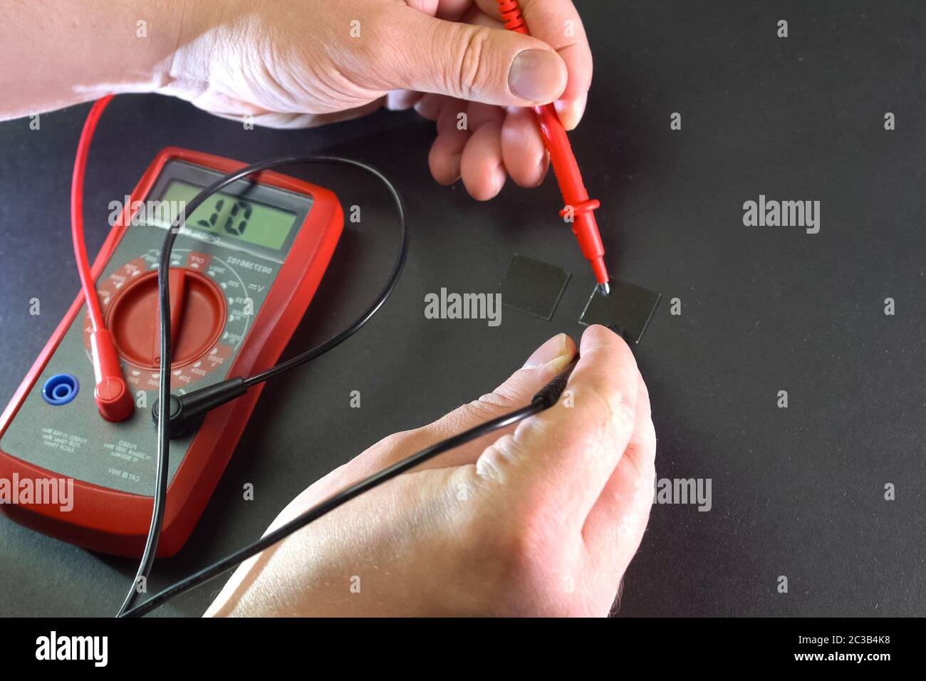 Misurazione dei parametri elettrici del prodotto mediante un multimetro. Foto Stock