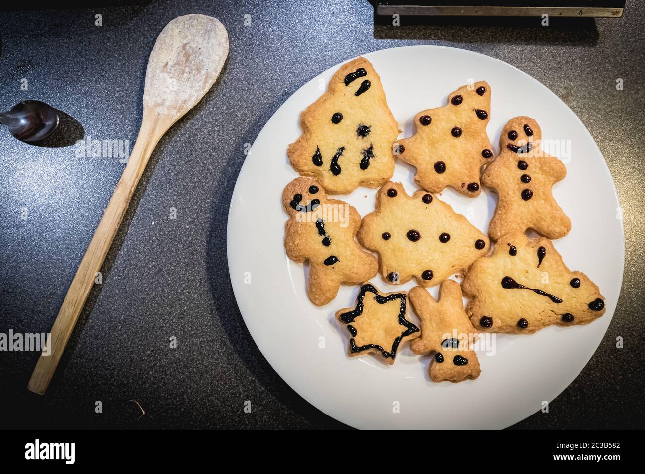 Biscotti shortbread di Natale in forma di abeti, stelle e pupazzi in un piatto bianco Foto Stock