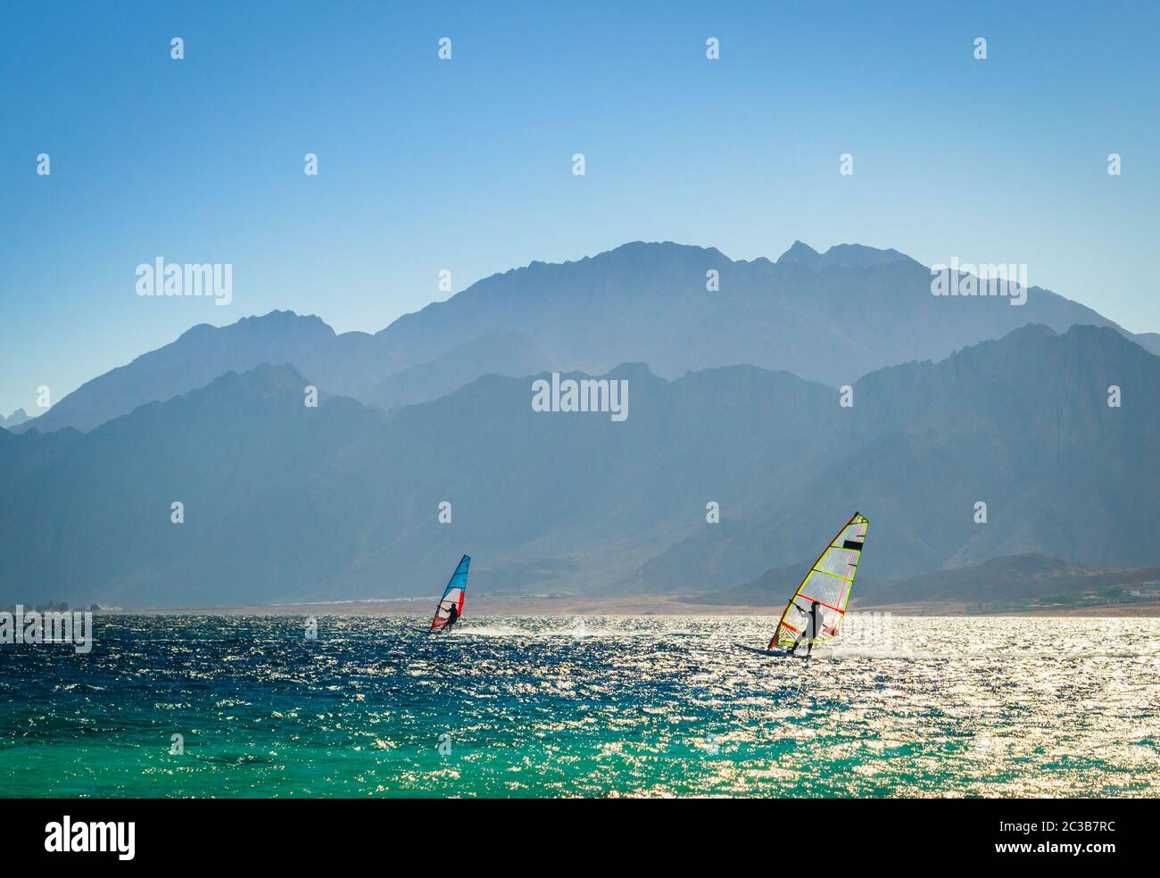 Surfisti cavalcare in mare sullo sfondo della costa rocciosa in Egitto Dahab Foto Stock