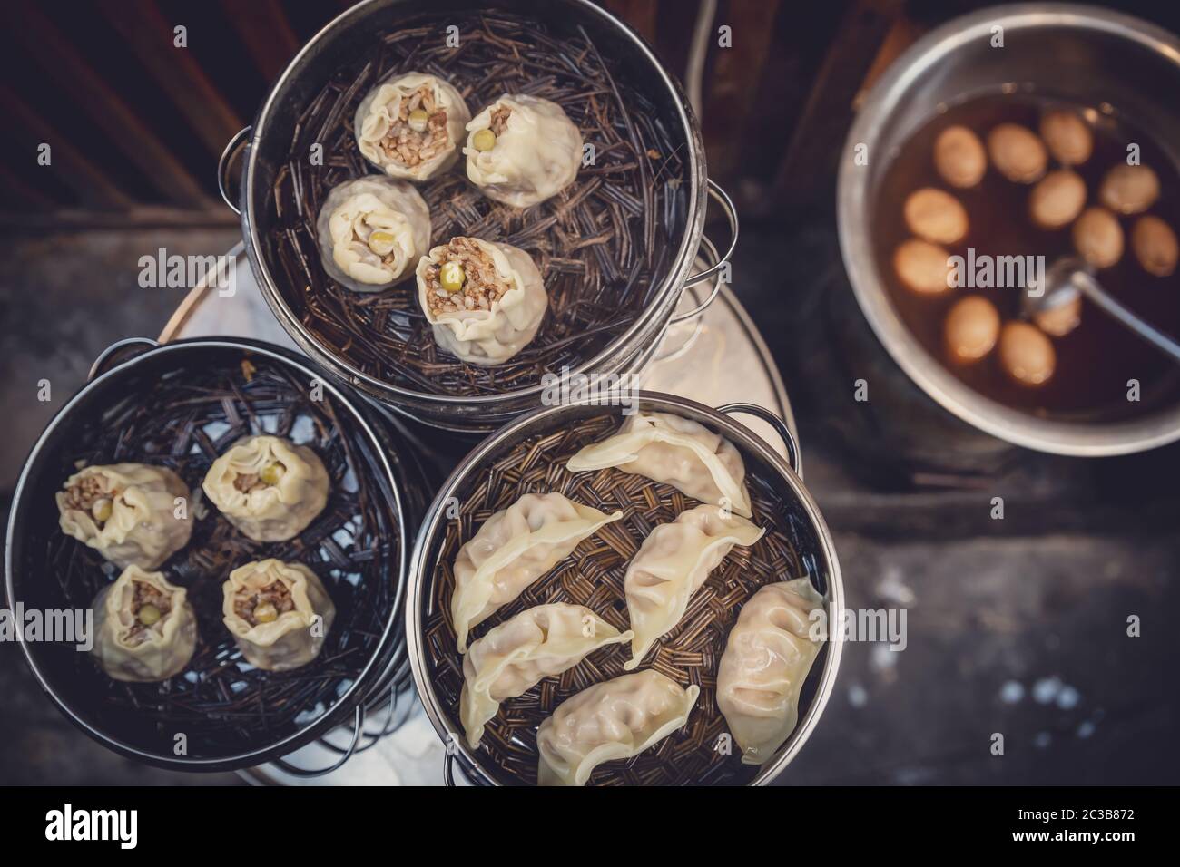 Deliziosi gnocchi cinesi tradizionali cotti al vapore e farciti con carne di maiale, preparati con vapore caldo, Cina Foto Stock