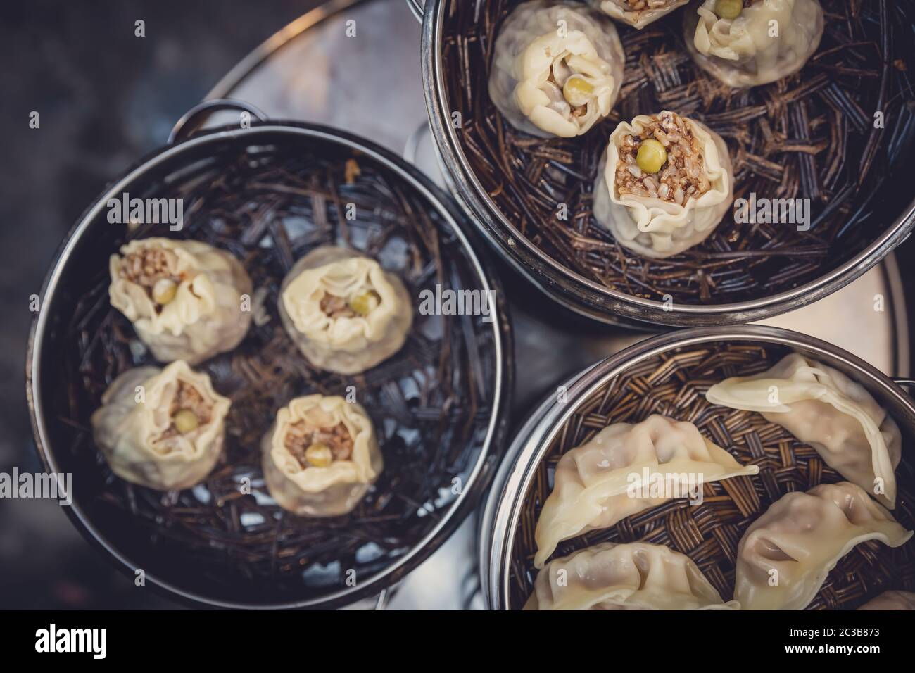 Deliziosi gnocchi cinesi tradizionali cotti al vapore e farciti con carne di maiale, preparati con vapore caldo, Cina Foto Stock