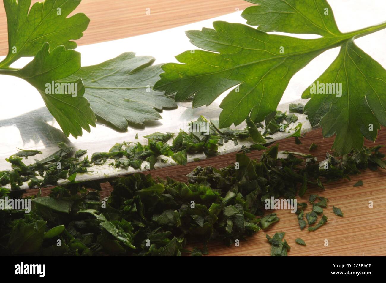 Primo piano di prezzemolo tritato con mezzaluna Foto Stock