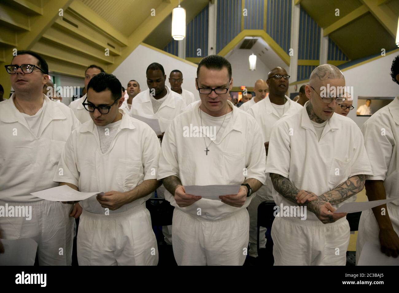 Rosharon Texas USA, agosto 25 2014: Detenuti maschi in uniforme nella prigione di Darrington hanno letto durante un programma nella cappella della prigione ad alta sicurezza. La sessione si inserisce nel corso del Seminario Teologico Battista del Sud-Ovest, al quale sono iscritti i prigionieri. ©Marjorie Kamys Cotera/Daemmrich Photography Foto Stock