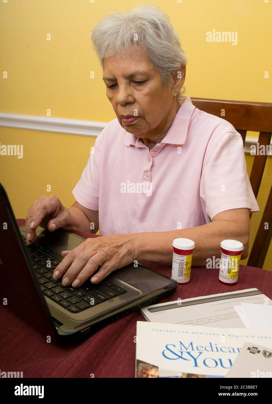 Austin Texas USA, gennaio 30 2014: Donna ispanica di 75 anni organizza il suo farmaco di prescrizione e cerca la loro idoneità con il suo Medicare e l'assicurazione supplementare. ©Marjorie Kamys Cotera/Daemmrich Photography Foto Stock